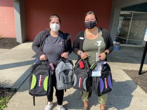 Natalie Orcutt and Rebecca Atwell holding youth backpacks donated to ALH